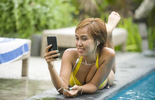 Joven atractiva y feliz mujer asiática en bikini usando social me — Foto de Stock