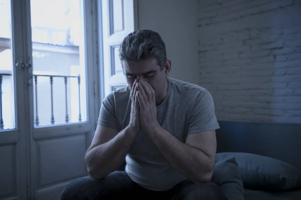 Hombre triste y preocupado con el pelo gris sentado en el sofá de casa buscando —  Fotos de Stock