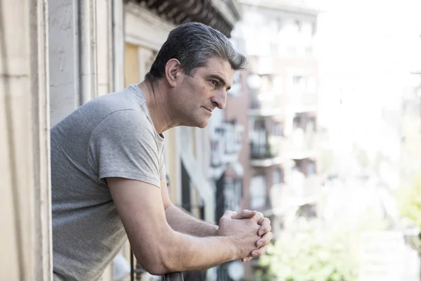 Sad and depressed 40s man looking through outdoors at home balco — Stock Photo, Image