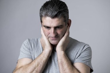 40'lı 50'li üzgün ve endişeli adam sinirli ve endişeli ve dalgın yüz ifadesinde gri izole düşünceli bakan