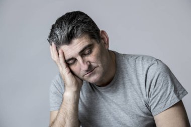 40'lı 50'li üzgün ve endişeli adam sinirli ve endişeli ve dalgın yüz ifadesinde gri izole düşünceli bakan