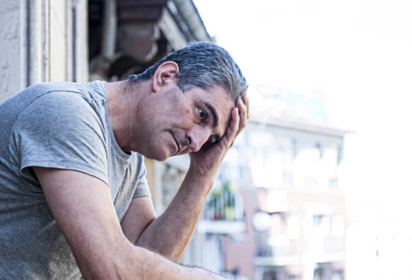 Trauriger und depressiver Mann in den Vierzigern schaut zu Hause durch die Fenster — Stockfoto