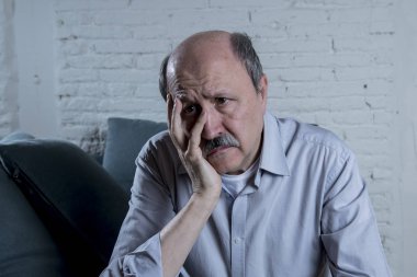 onun 60s evde kıdemli olgun yaşlı adamı portresi kanepe yalnız duygu üzgün ve endişeli ağrı ve depresyon acı