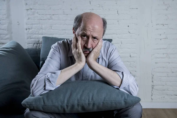 Potret seorang pria tua dewasa di sofa rumahnya yang berusia 60-an sendirian merasa sedih dan khawatir menderita rasa sakit dan depresi — Stok Foto