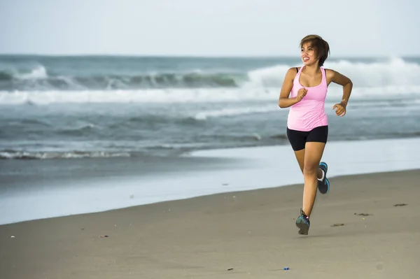 Muda menarik dan fit pelari wanita Asia berlari di pantai sisi laut tersenyum gembira dalam kebugaran — Stok Foto