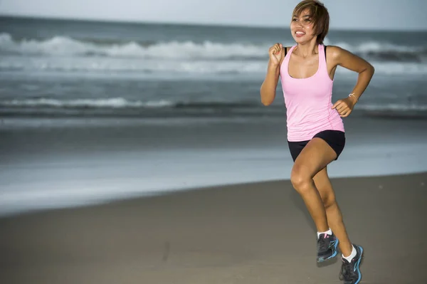 Muda menarik dan fit pelari wanita Asia berlari di pantai sisi laut tersenyum gembira dalam kebugaran — Stok Foto