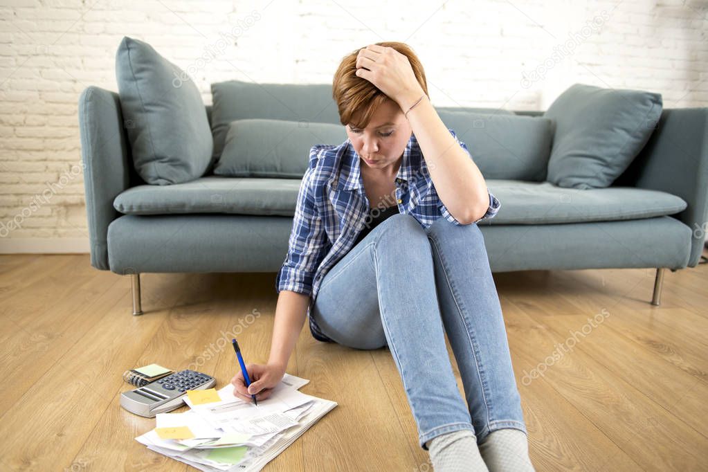 young sad worried and desperate woman banking and accounting home monthly and credit card expenses on living room floor
