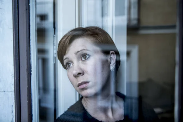 Portretul dramatic al unei tinere femei frumoase care gândește și se simte tristă suferind depresie la fereastra casei arătând deprimată — Fotografie, imagine de stoc