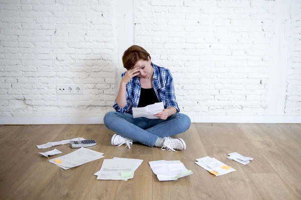 Mulher no chão da sala de estar com calculadora e banco e contas papelada e documentos fazendo contabilidade financeira doméstica — Fotografia de Stock