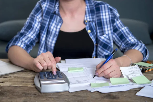 Woman banking and accounting home monthly and credit card expenses with computer laptop doing paperwork with calculator — Stock Photo, Image