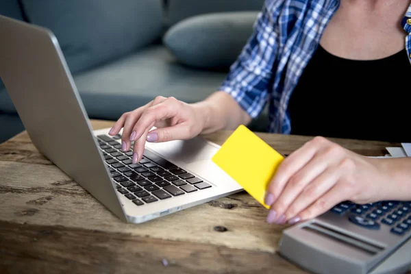 Îndeaproape mâna unei femei care deține cumpărături cu carduri de credit online sau bancar pe internet cu laptop-ul acasă în finanțele interne — Fotografie, imagine de stoc