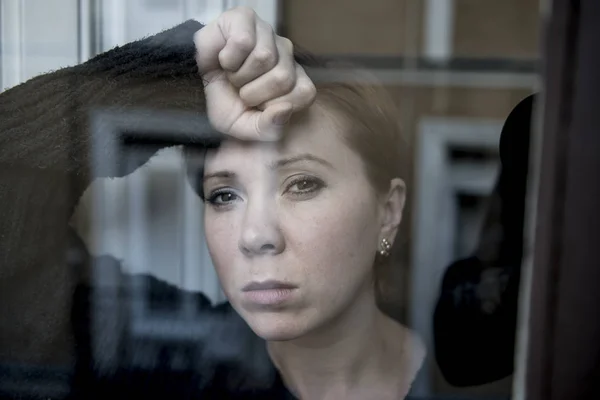 Dramatic close up portrait of young beautiful woman thinking and  feeling sad suffering depression at home window looking depressed — Stock Photo, Image