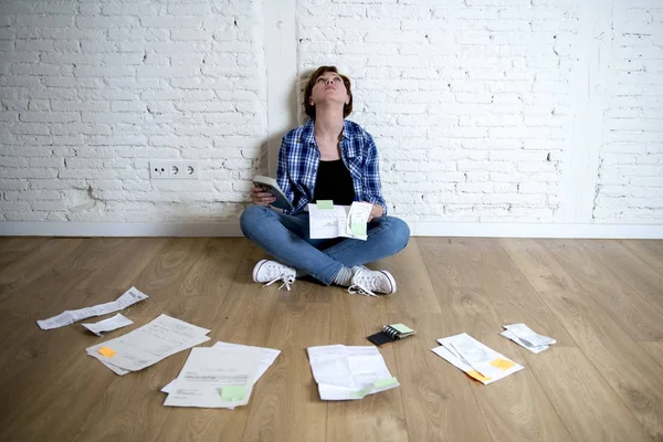 woman at living room floor with calculator and bank and bills paperwork and documents doing domestic financial accounting