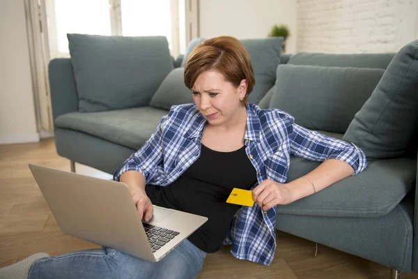 Muda menarik dan bahagia wanita di sofa rumah dengan kartu kredit dan komputer laptop belanja di baris atau rekening dalam negeri perbankan — Stok Foto