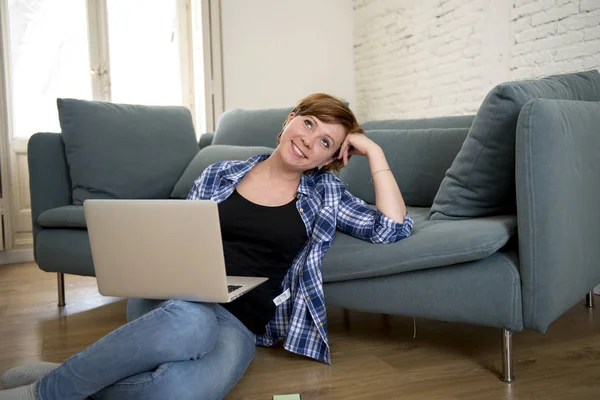 Joven mujer atractiva y feliz en el sofá de casa relajado y soñador utilizando ordenador portátil de compras en línea sonriendo emocionado —  Fotos de Stock