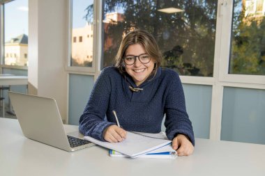 Resepsiyon dersinize gülümseyen okul sınıf bilgisayar laptop ile çalışan genç mutlu kadın genç üniversite öğrencisi 