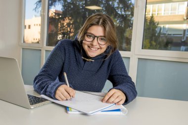 Resepsiyon dersinize gülümseyen okul sınıf bilgisayar laptop ile çalışan genç mutlu kadın genç üniversite öğrencisi 