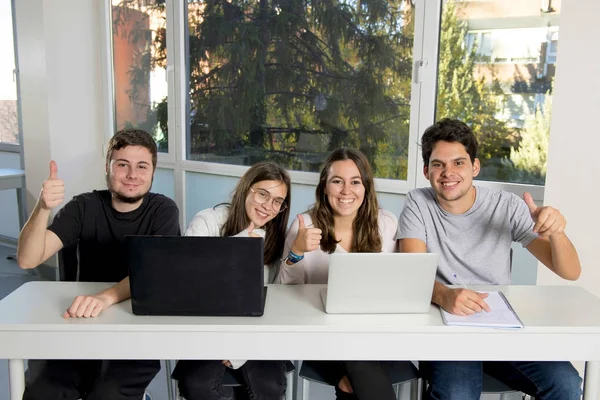 Gruppe junger männlicher und weiblicher Teenager-Universitätsstudenten in der Schule, die im Klassenzimmer sitzen und gemeinsam an einem Projekt arbeiten — Stockfoto