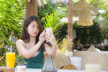 Çinli cep telefonu zevk internet kullanan kadın sosyal medya açık havada kahve dükkanında sohbet gönderen metin rahat Asyalı güzel 