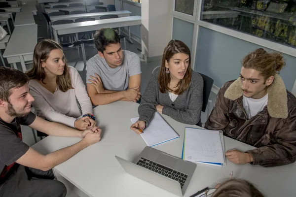 Grupo de jóvenes estudiantes universitarios adolescentes en la escuela sentados en el aula de aprendizaje y trabajando en el proyecto junto con el ordenador portátil —  Fotos de Stock