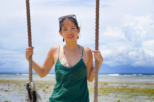 Glücklich asiatische chinesische Frau mit Schaukelseil Spaß haben isoliert auf einem sommerblauen Himmel lächelt positiv und fröhlich im Urlaub — Stockfoto