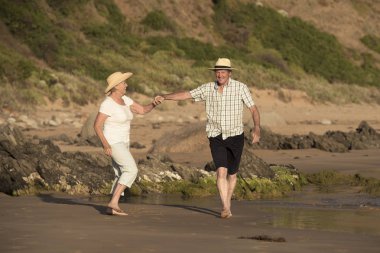 birlikte romantik yaşlanma içinde plaj deniz kıyısında mutlu ve rahat yürüyüş güzel kıdemli Olgun çift kendi 60s veya 70 li yıllarda emekli 