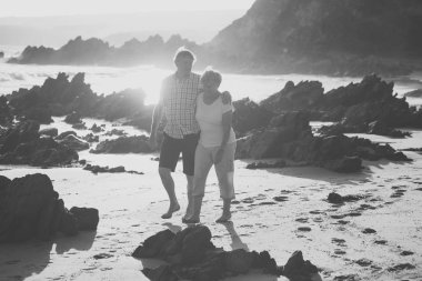 birlikte romantik yaşlanma içinde plaj deniz kıyısında mutlu ve rahat yürüyüş güzel kıdemli Olgun çift kendi 60s veya 70 li yıllarda emekli 