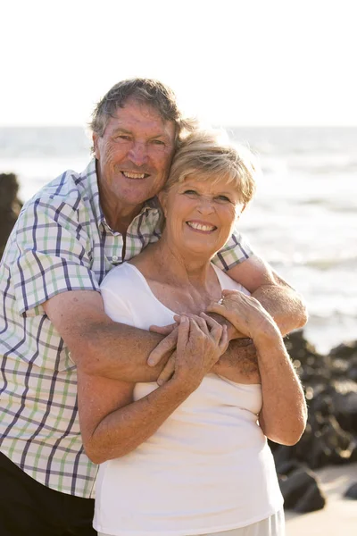 Pasangan senior yang cantik pada usia 60-an atau 70-an pensiunan berjalan bahagia dan santai di pantai pantai dalam usia romantis bersama-sama — Stok Foto
