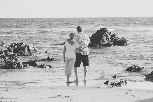 Charmant couple d'aînés âgés de 60 ou 70 ans à la retraite marchant heureux et détendu sur la plage bord de mer dans le vieillissement romantique ensemble — Photo