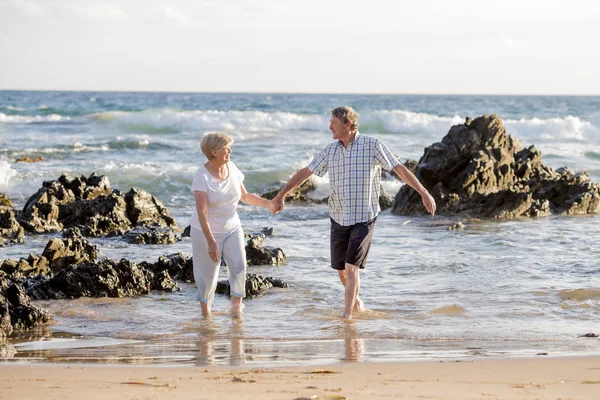 Милая взрослая пара в возрасте 60-70 лет на пенсии ходьба счастливая и расслабленная на берегу моря в романтическое старение вместе — стоковое фото