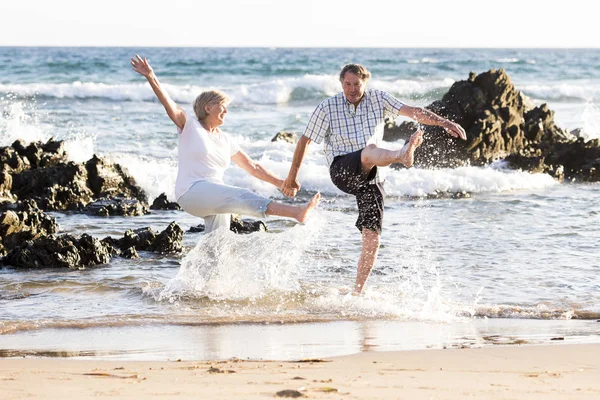 Lovely senior mature couple on their 60s or 70s retired walking happy and relaxed on beach sea shore in romantic aging together — Stock Photo, Image