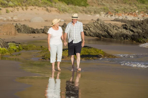 Lovely senior mature couple on their 60s or 70s retired walking happy and relaxed on beach sea shore in romantic aging together — Stock Photo, Image