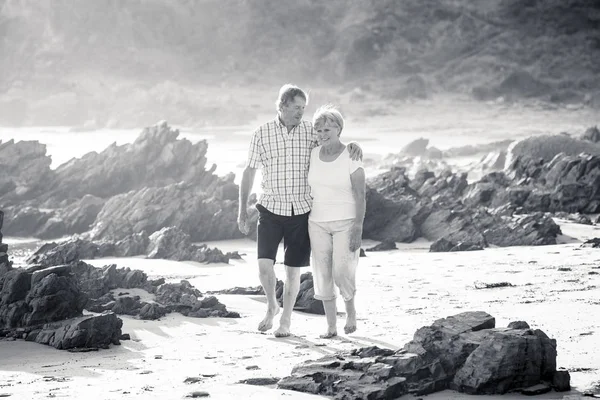 60 歳代や 70 年代の素敵なシニア中高年カップル引退歩いて幸せでリラックスして一緒にロマンチックな加齢に伴うビーチ海岸 — ストック写真