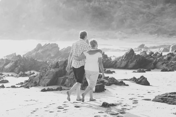 Bella coppia anziana matura sui loro anni '60 o' 70 in pensione a piedi felice e rilassato sulla spiaggia riva del mare in invecchiamento romantico insieme — Foto Stock