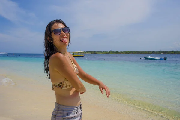 Joven hermosa china asiática chica en bikini divertirse burlándose con la lengua en la playa con increíble hermosa agua de mar turquesa — Foto de Stock