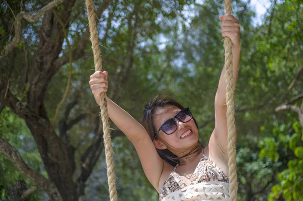 無料夏の休日熱帯旅行で幸せな気持ちを楽しむビーチ木のブランコを楽しんで若い美しい中国アジアの女の子 — ストック写真