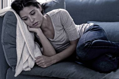 genç çekici latin kadın evde oturma odası kanepe yalan yorgun ve depresyon duygu üzgün ve umutsuz bir baş ağrısı ile acı endişeli