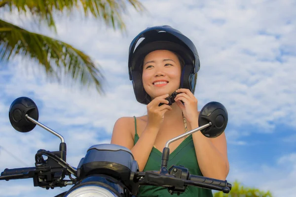 Fiatal szép boldog és aranyos ázsiai kínai nő beállító lovaglás a robogó motor elszigetelt a kék ég, a biztonsági koncepció bukósisak — Stock Fotó