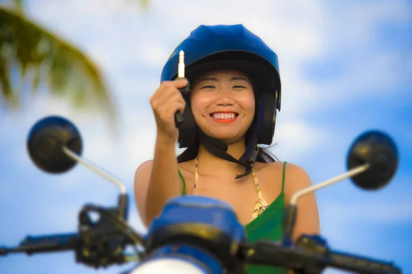 Hübsche asiatische chinesische Mädchen zeigt Schlüssel des neuen Motorrads trägt Motorradhelm lächelnd stolz in Roller Kauf und Vermietung — Stockfoto