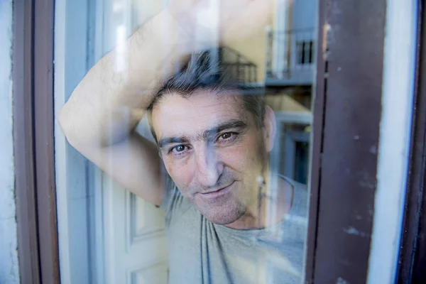 Attractive and happy grey hair man on his 40s or 50s looking throw window glass leaning tranquil and satisfied looking thoughtful and daydreaming — Stock Photo, Image