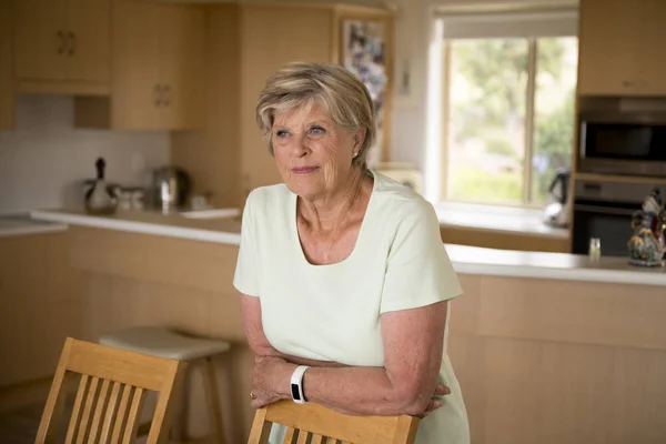 Hermoso retrato de mujer madura mayor bonita y dulce en la mediana edad alrededor de 70 años de edad sonriendo feliz y amable en la cocina casera —  Fotos de Stock