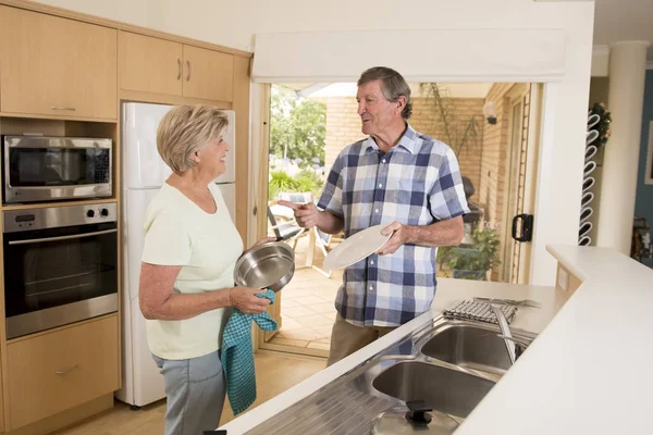 Senior beautiful middle age couple around 70 years old smiling happy at home kitchen washing the dishes looking sweet together — Stock Photo, Image