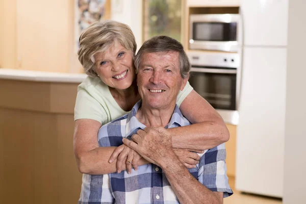 Старша красива пара середнього віку приблизно 70 років посміхається щасливо разом на домашній кухні виглядає солодко в житті чоловік і дружина концепції — стокове фото