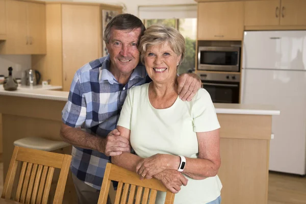 Старша красива пара середнього віку приблизно 70 років посміхається щасливо разом на домашній кухні виглядає солодко в житті чоловік і дружина концепції — стокове фото
