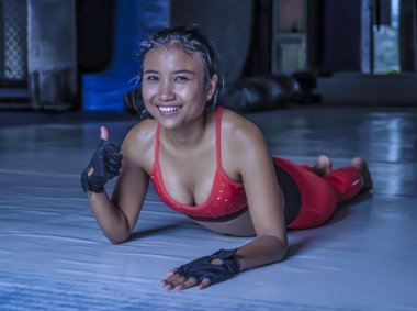 Genç mutlu ve güzel terli Asyalı kadın zor eğitim kurumsal poz gülümseyen jimnastik salonu dojo katta germe spor giyim 