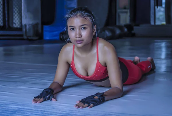 Jovem bonito suado asiático mulher no esporte roupas esticando no ginásio dojo chão sorrindo posando corporativa no duro treino de treinamento — Fotografia de Stock
