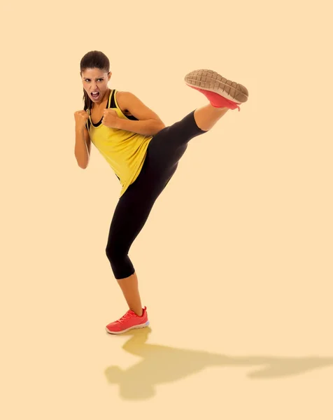 Beautiful and furious girl in fitness clothes training martial arts kick attack looking angry and upset in sports, self defense and healthy lifestyle — Stock Photo, Image