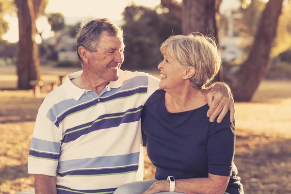 Vintage filter portrait of American senior beautiful and happy mature couple around 70 years old showing love and affection smiling together in the park — Stock Photo, Image