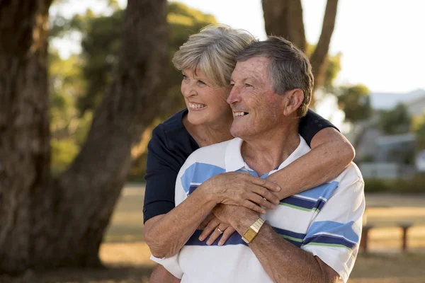 Portrait of American senior beautiful and happy mature couple around 70 years old showing love and affection smiling together in the park — Stock Photo, Image