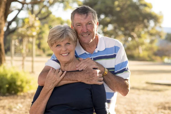 Retrato de americano senior hermosa y feliz pareja madura alrededor de 70 años de edad mostrando el amor y el afecto sonriendo juntos en el parque — Foto de Stock
